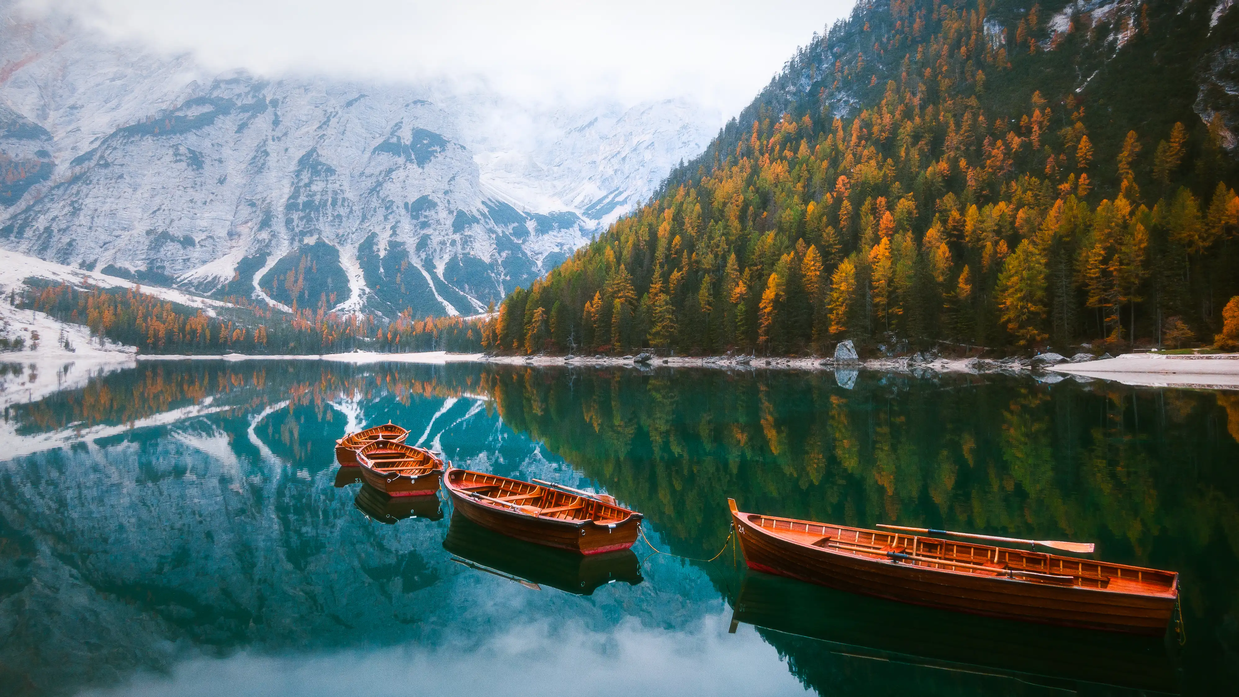 Lago di Braies at dawn with Dolomite peaks reflected in turquoise water
