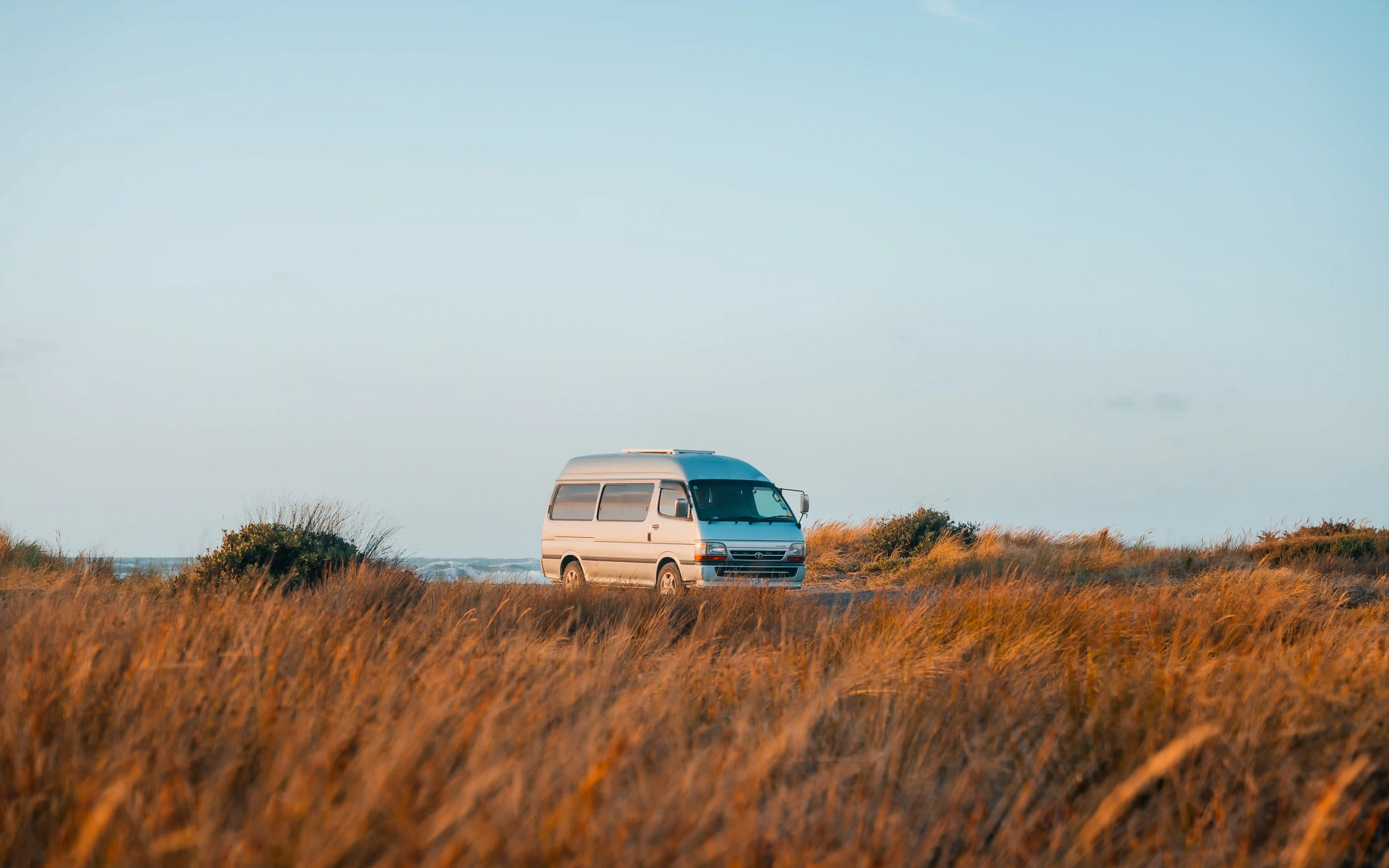 Campervan at Otaki River North Bank coastal campsite at sunset