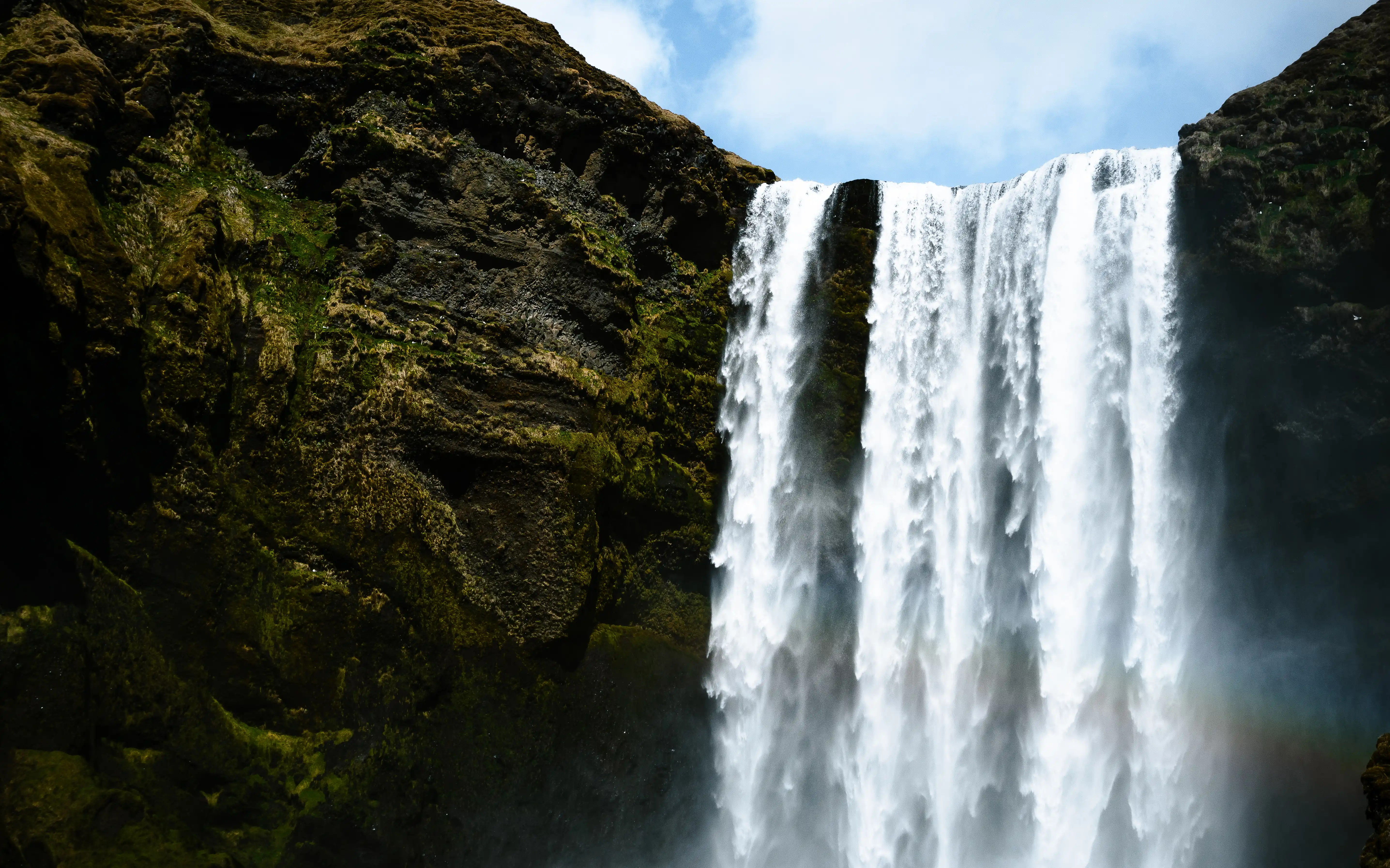 Skogafoss waterfall in Iceland with rainbow forming in the mist